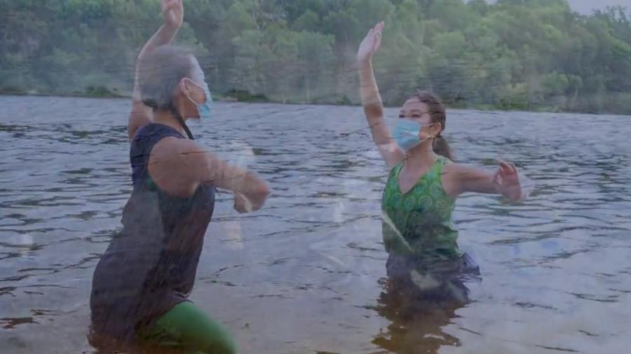 Two dancers perform in a body of water