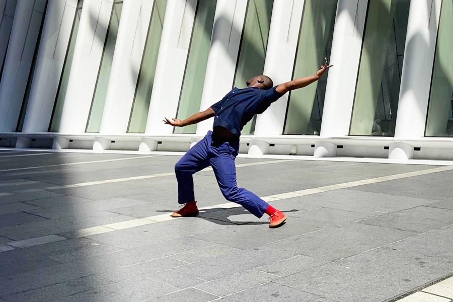 A person dances in an urban setting.