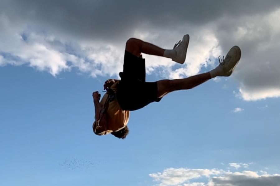 A person floats mid air with nothing but sky behind them.