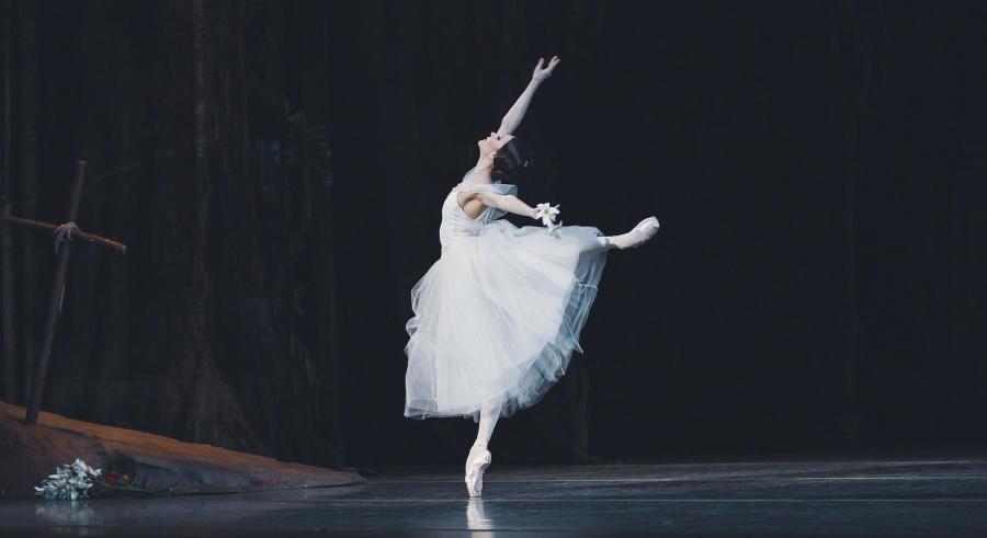 A ballerina in white strikes a powerful pose.
