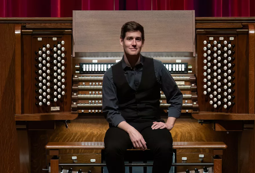 Greg sits on the Northrop organ bench facing the audience