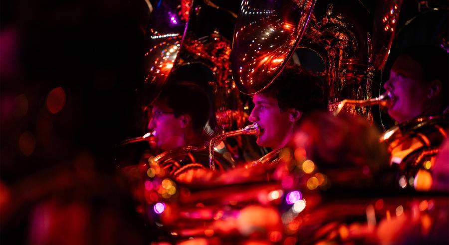 Close up shot of tuba players lit red on stage.