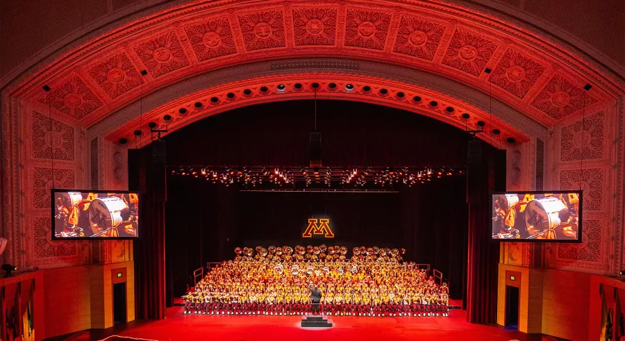 The full University of Minnesota Marching Band on the Northrop stage.