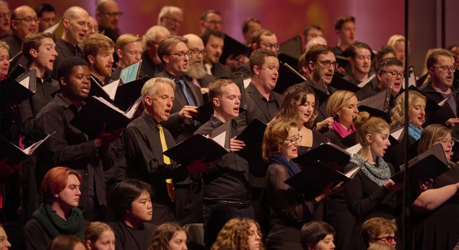 Choral members sing from books.
