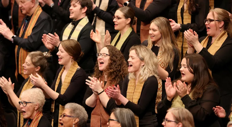 VocalEssence chorus claps and sings.
