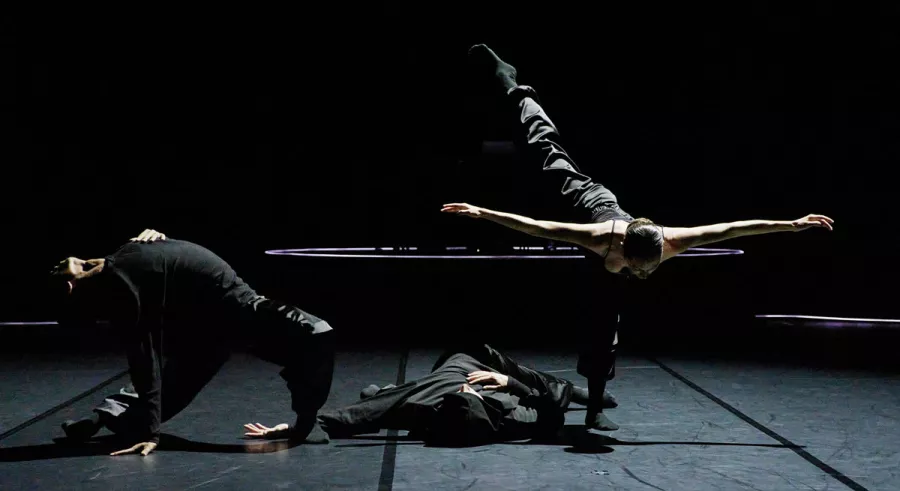 Three A a | a B - BEND company members frozen in varying dance postitions: backbend, laying down, and a forward lean. 