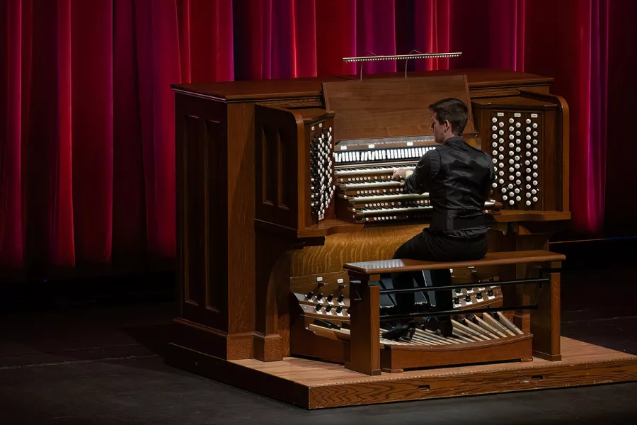 Greg Zelek, a man in dress clothes, plays the Northrop pipe organ.