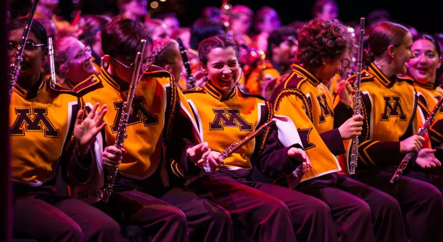 Members of the flute section in the UMN Marching Band laughing. 