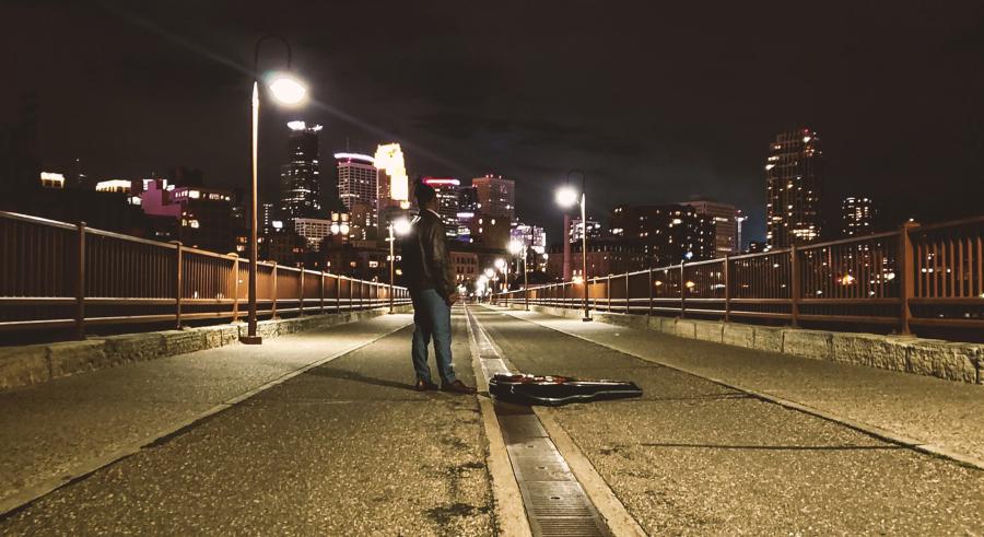 DeTrell Melodies staning on a bridge to downtown Minneapolis
