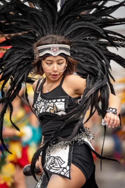 woman danceing in black beaded tank top and black feather headdress