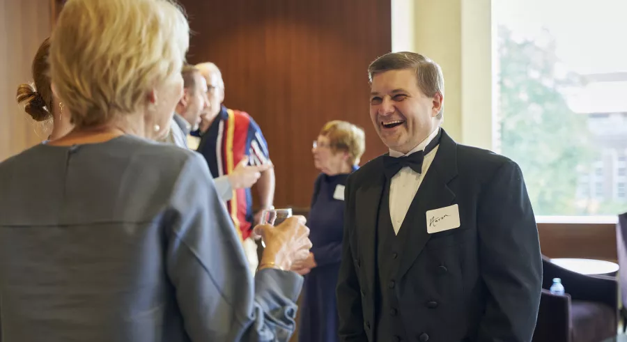 Organist Aaron David Miller smiles while talking to a patron.