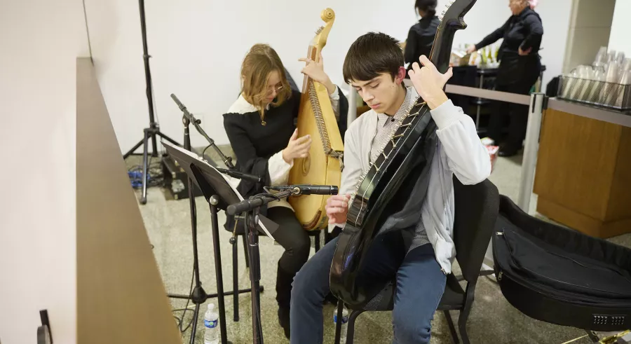 Two musicians hold traditional Ukrainian stringed instruments.