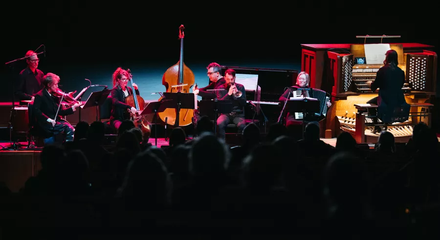 Dreamland Faces string musicians and an organist playing the organ seated on Northrop stage.