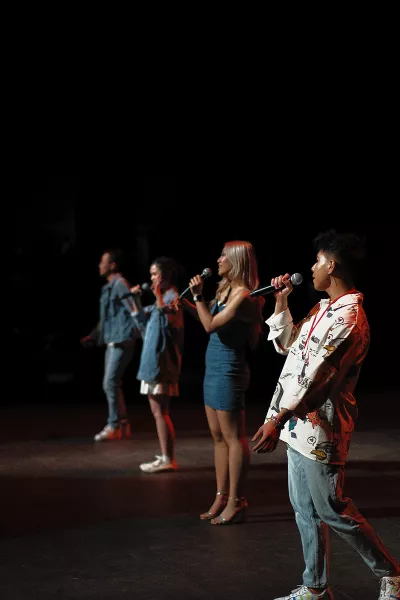 People stand on stage singing