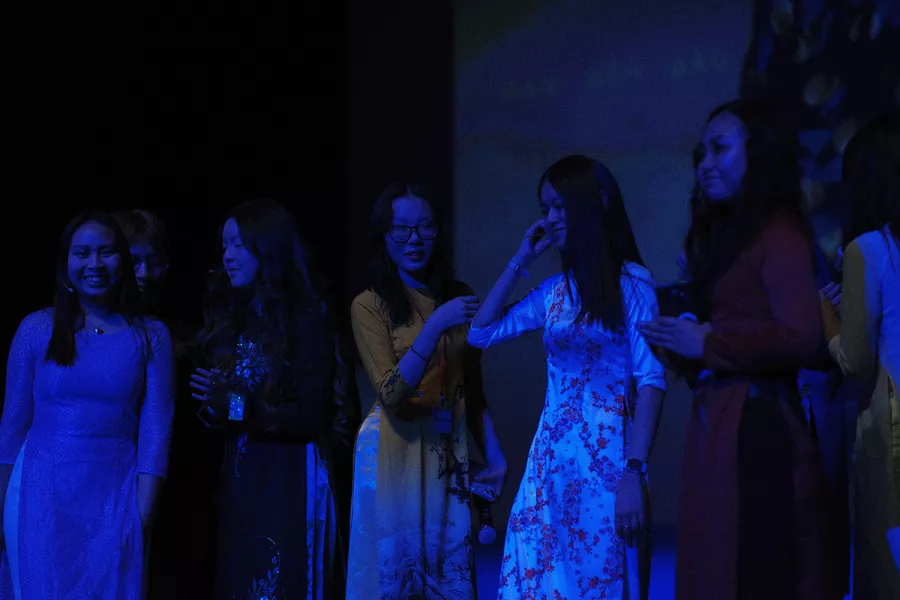 woman stand on stage with a blue light on them