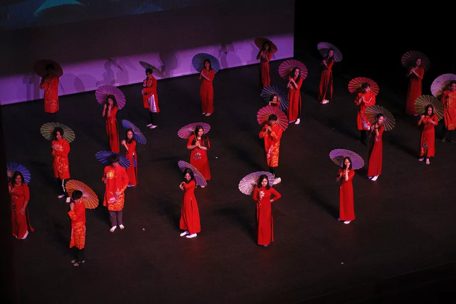 woman in red dresses stand on stage