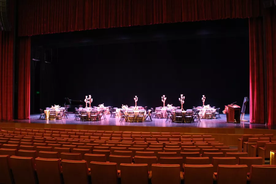 The Carlson Family Stage with circular banquet tables and chairs set up on it.