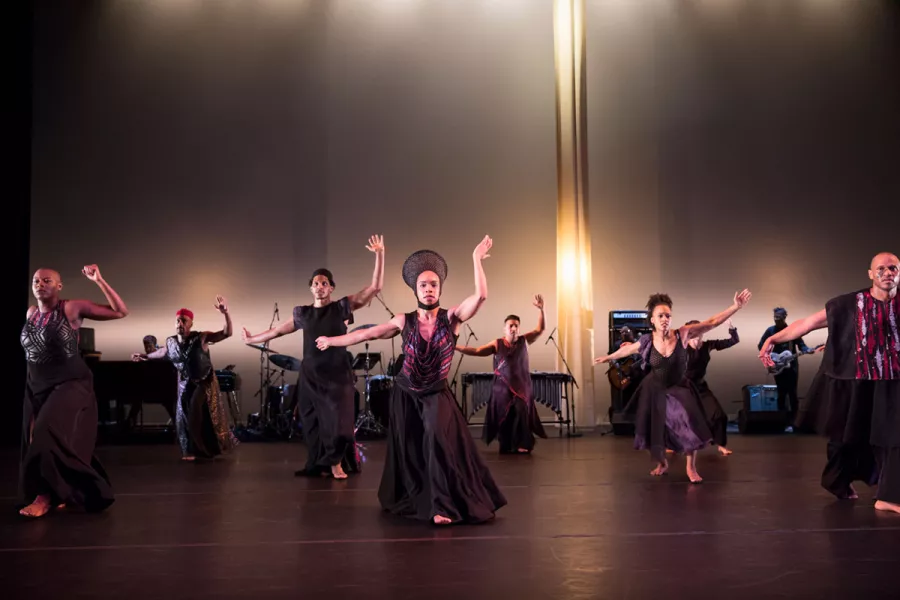 A group of dancers perform together on stage.