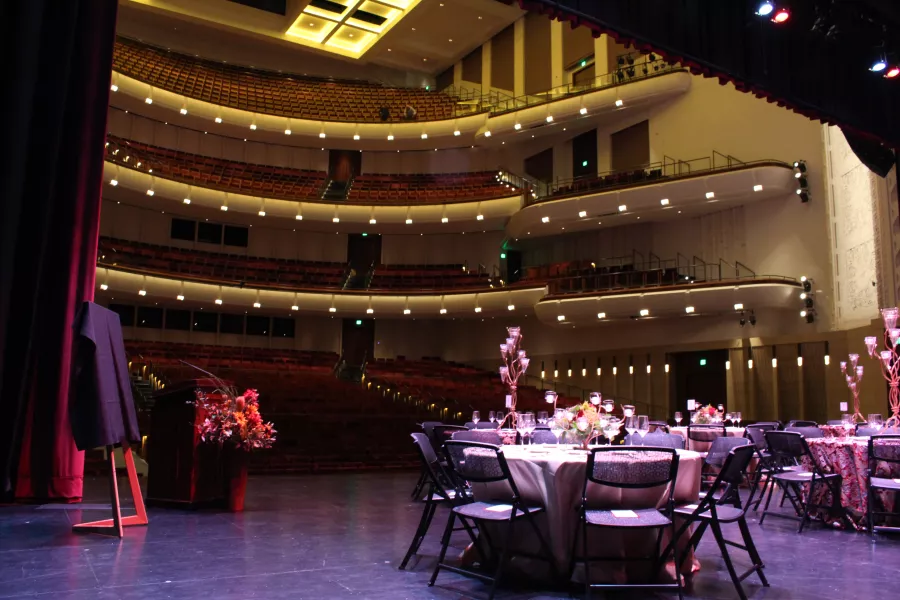 The Carlson Family Stage with circular banquet tables and chairs set up on it.