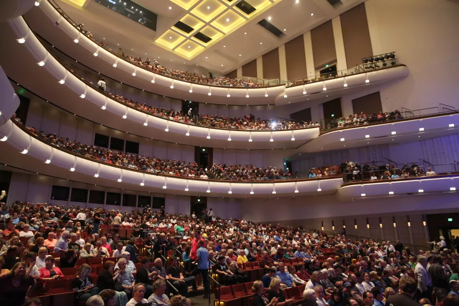 The seats and levels in the Northrop Auditorium taken from the lowest level. The theatre is filled with audience members.
