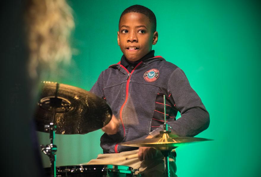 Young boy plays the drums